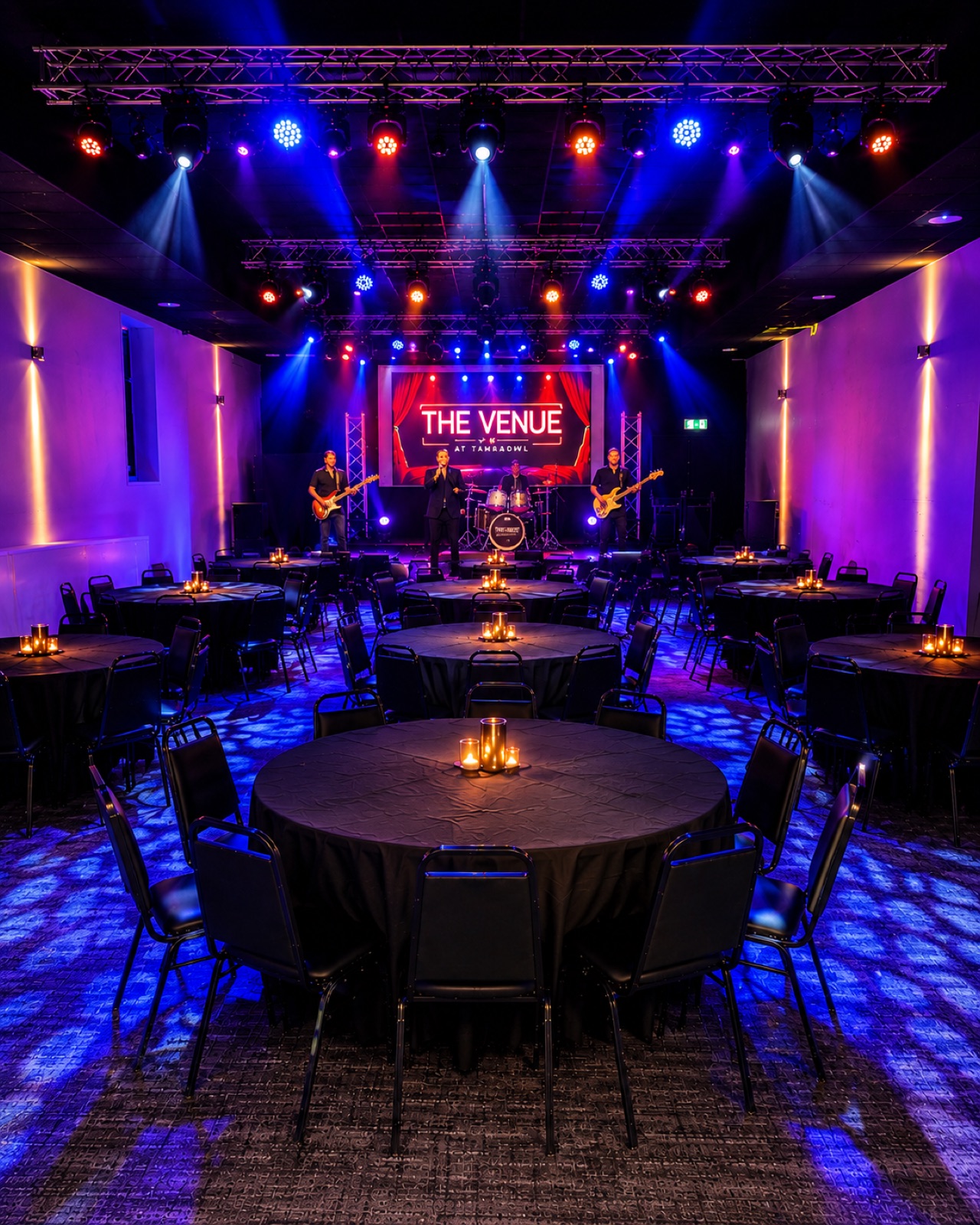 The Venue set up cabaret-style with round tables and candlelight facing the stage